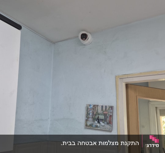 מצלמת אבטחה מותקנת בפינת חדר עם קיר כחול